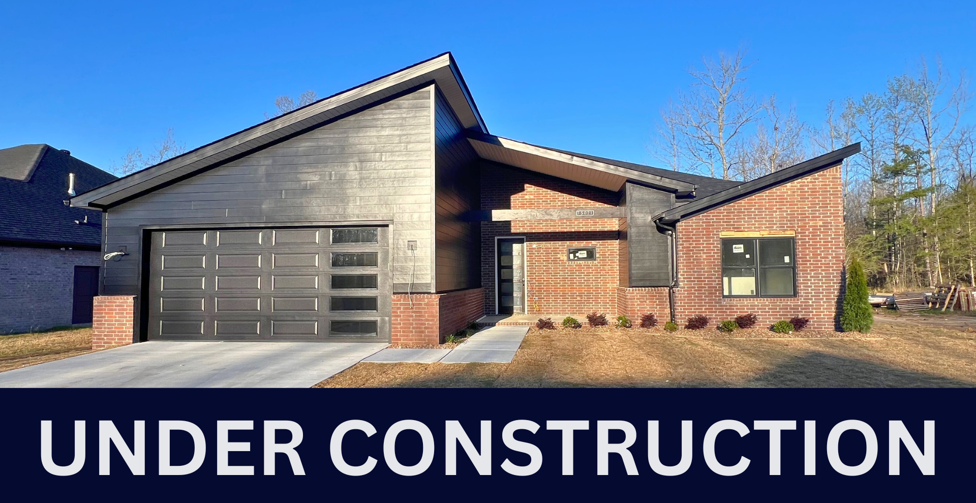 Modern new construction home with black garage door and dark brick exterior