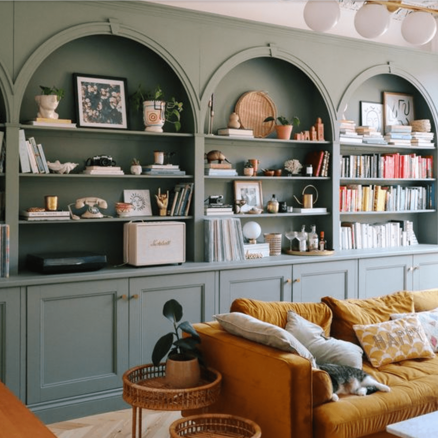 sage green custom shelves built in an office to hold books and other decorations