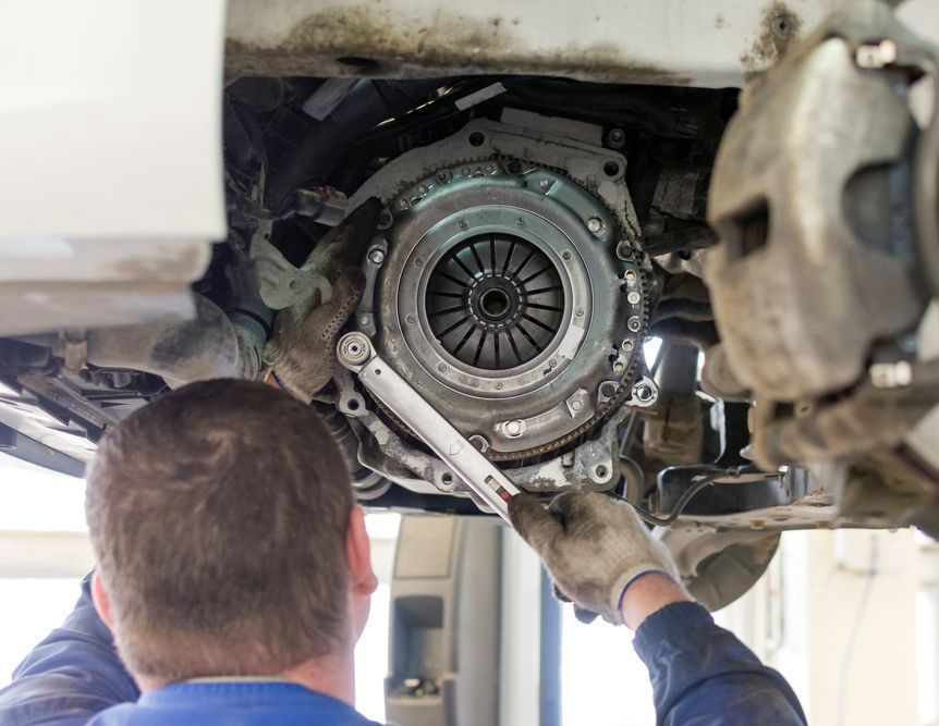 A Man Is Fixing A Clutch On A Car With A Wrench — Valley Brake & Clutch In McDougalls Hill, NSW