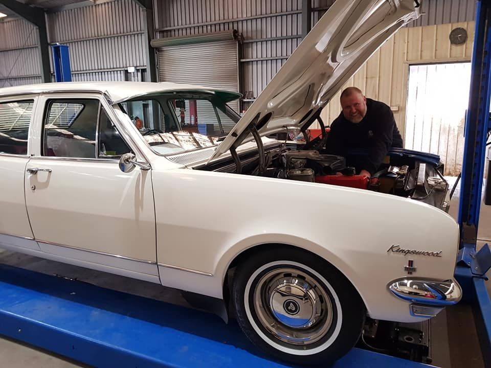 A Man is Working on a White Car With the Hood Open in a Garage — Valley Brake & Clutch In McDougalls Hill, NSW