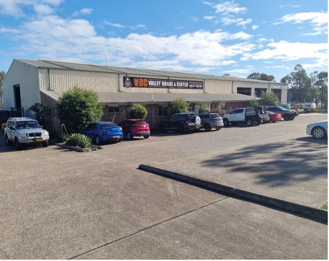 A Row of Cars Are Parked in Front of a Building — Valley Brake & Clutch In McDougalls Hill, NSW