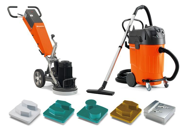 Orange and black industrial vacuum with hose, plus assorted floor-scrubber attachments on a white background