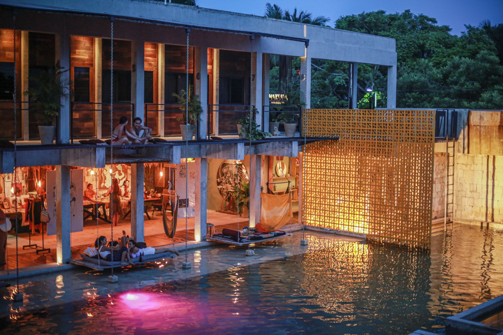 Vista de la alberca del hotel Makaaá con sus redes tipo hamaca para tomar el sol.