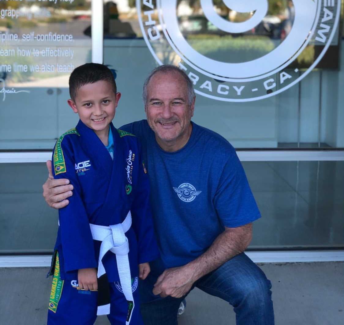 A man and a boy are posing for a picture in front of a sign that says legacy