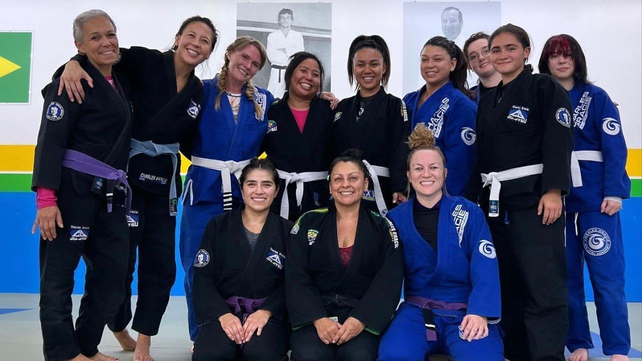 A group of women in karate uniforms are posing for a picture.