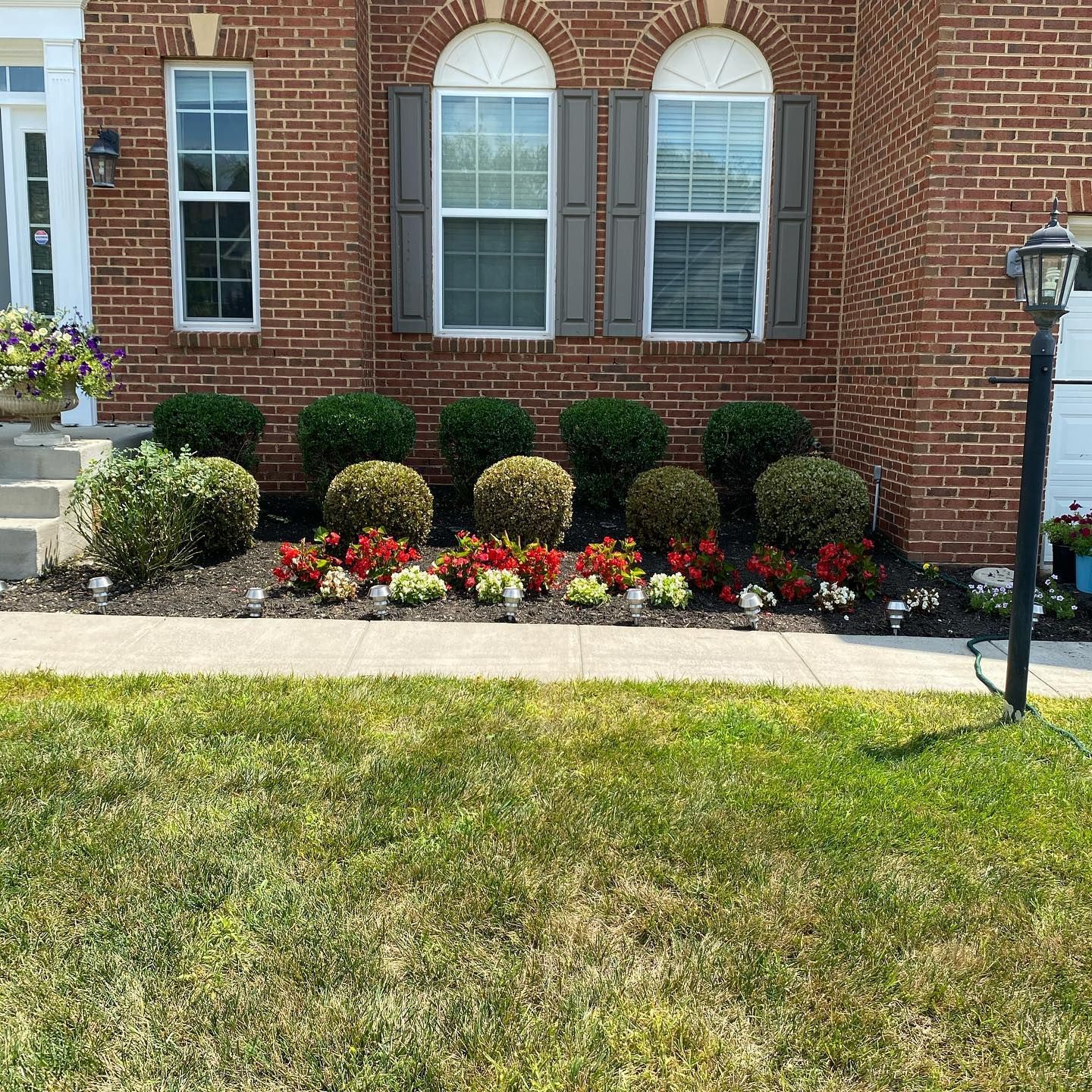 A brick house with a lush green lawn in front of it