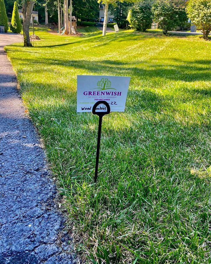 A sign is sitting in the middle of a lush green field.