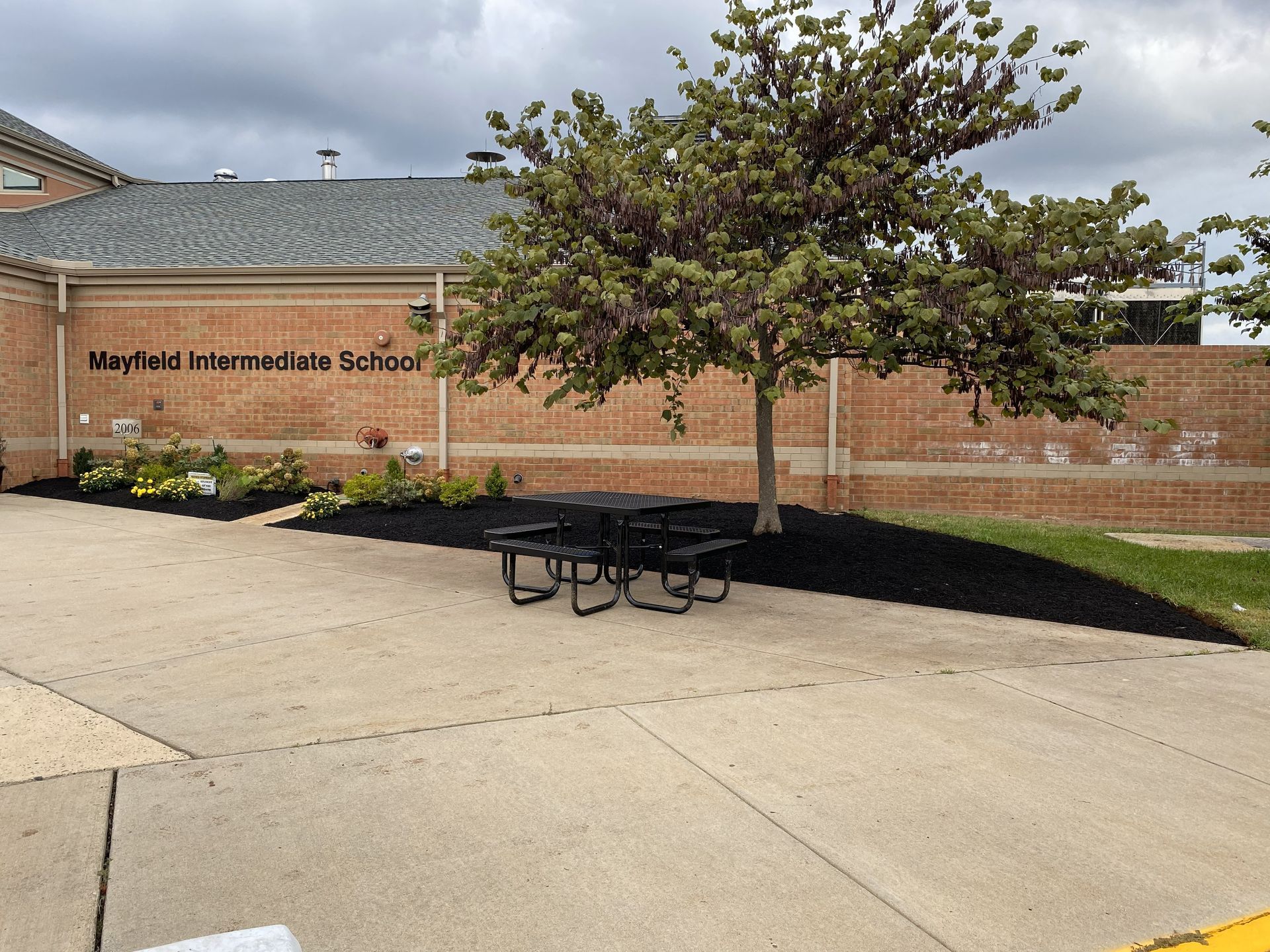 Commercial school landscaping project in Manassas, Virginia, featuring fresh mulch beds, seasonal plantings, and maintained entrance areas by GreenWish.