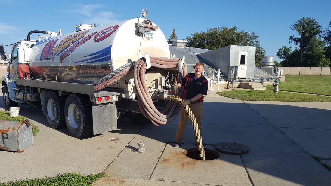 a man is standing in front of a septic tank truck 