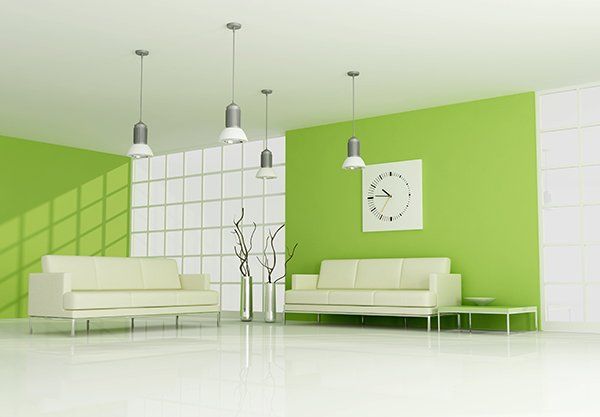 A living room with green walls and white furniture