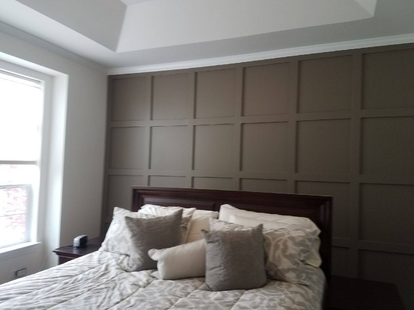 A bedroom with a bed , nightstand , and window.