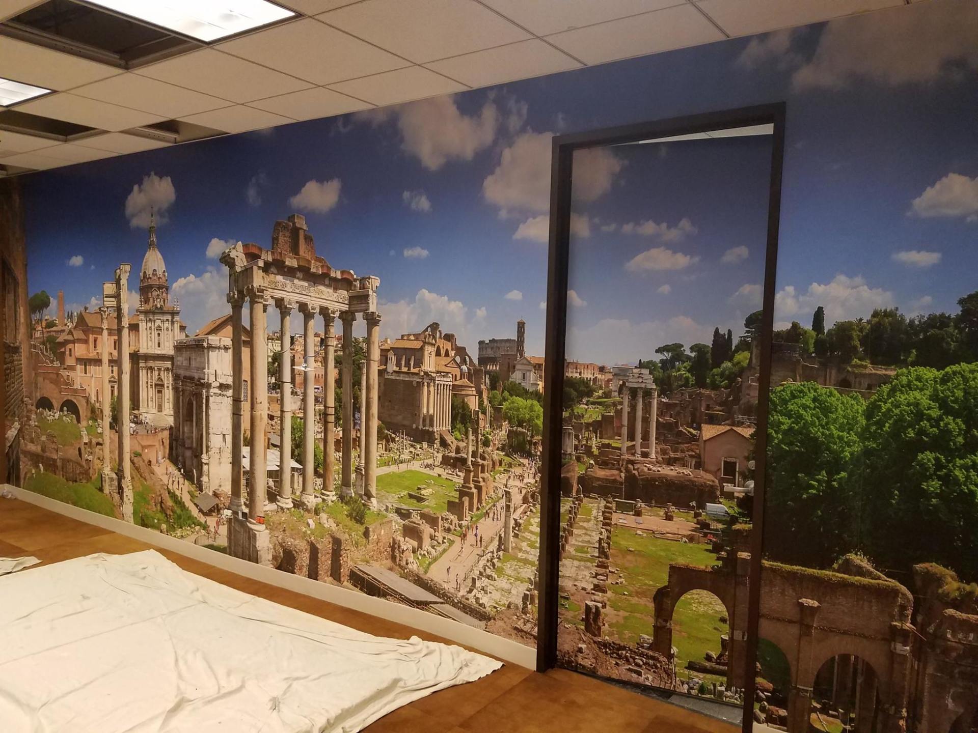 A room with a picture of a ruined city on the wall
