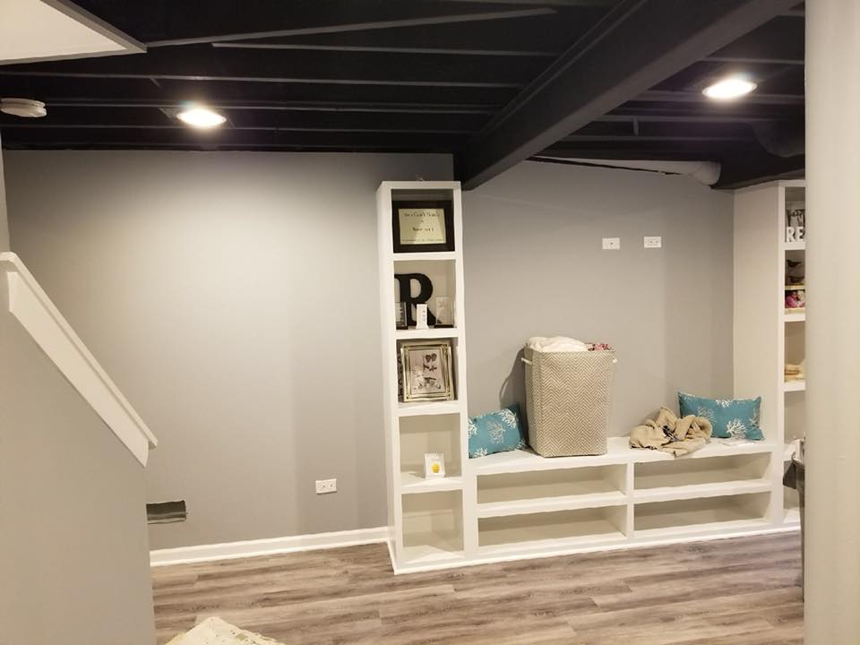 A basement with a bench and shelves in it.