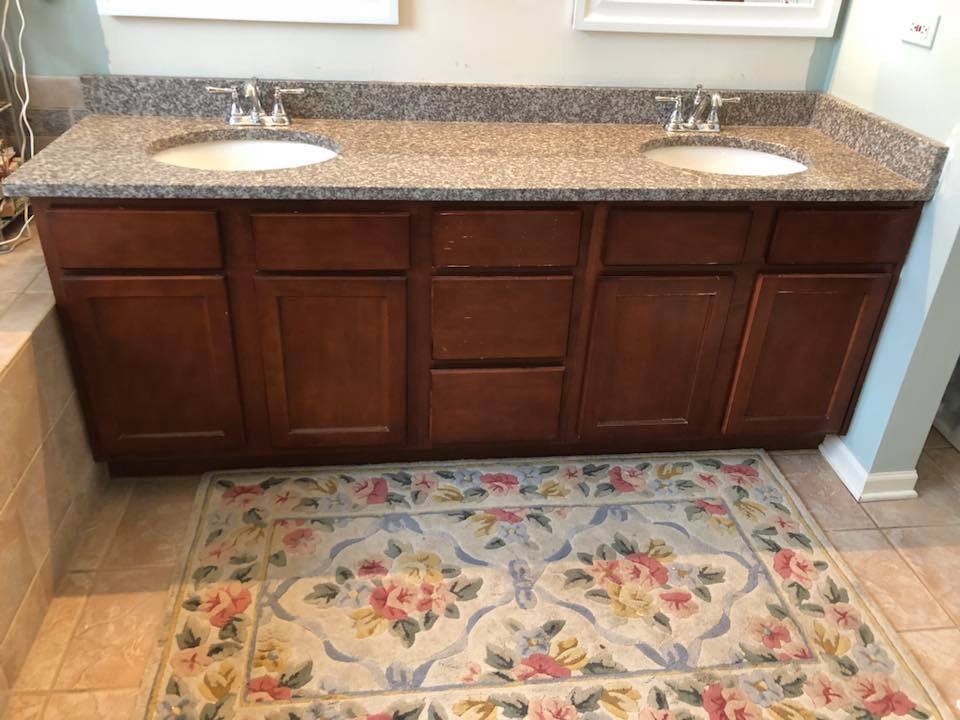 A bathroom with two sinks and a rug on the floor