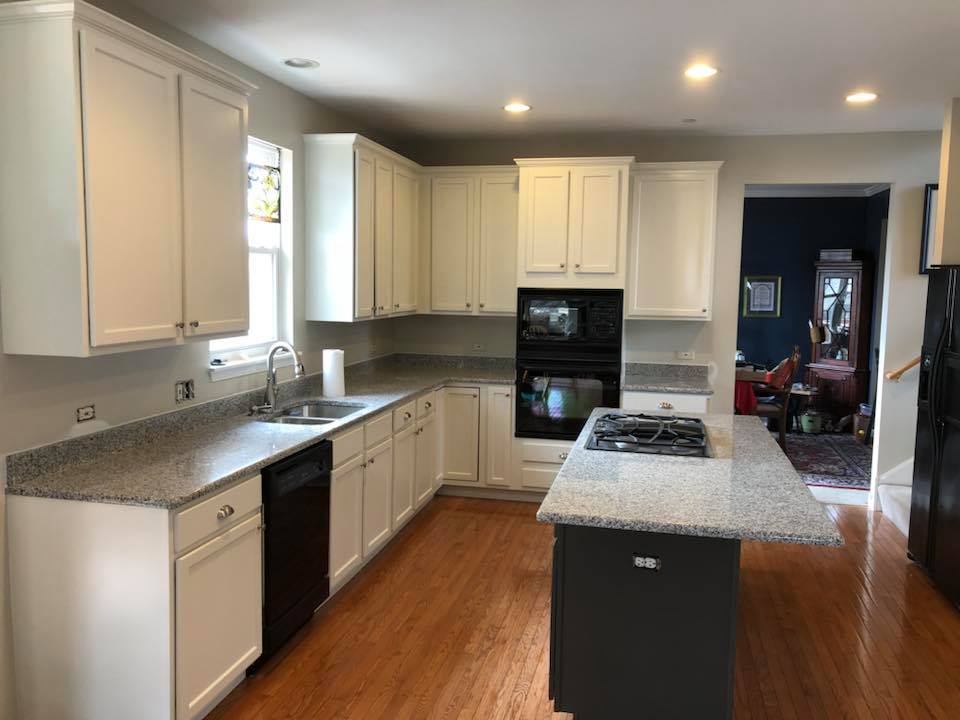 A kitchen with white cabinets and granite counter tops