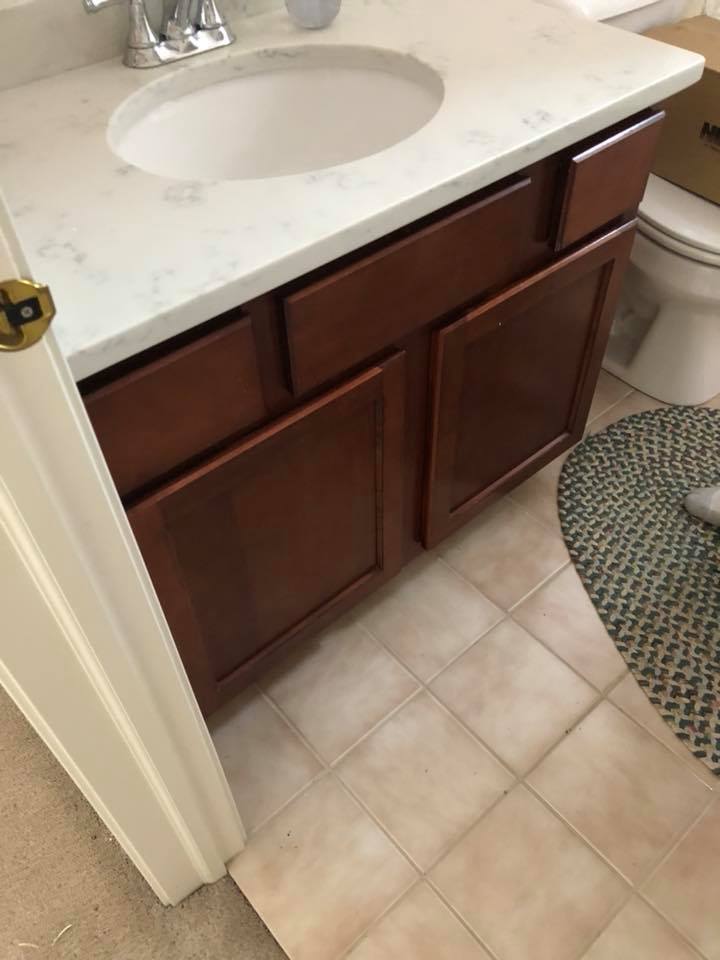 A bathroom with a sink , toilet , and rug.