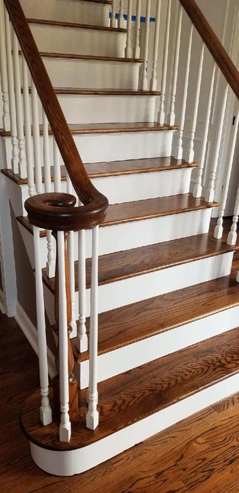 A wooden staircase with white railings and wooden steps in a house.