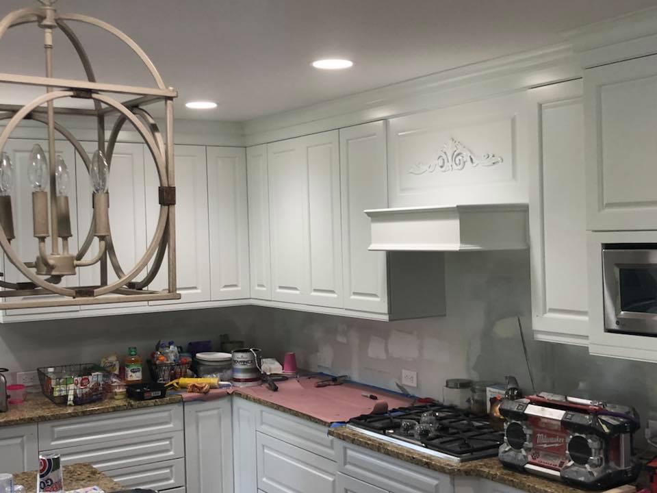 A kitchen with white cabinets and granite counter tops is being remodeled.