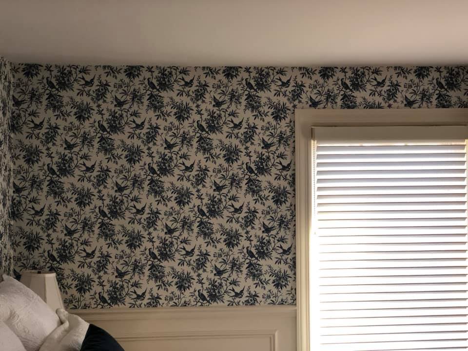 A bedroom with a bed and a window with blinds.