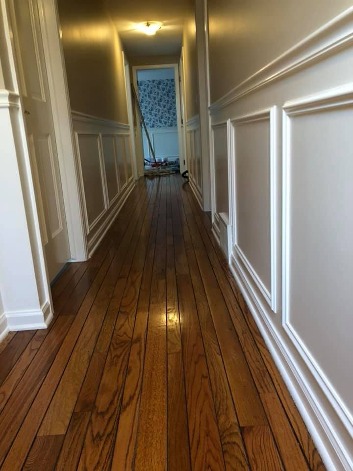 A long hallway with wooden floors and white trim.