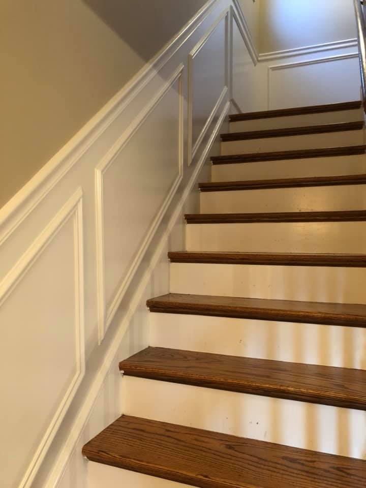 A set of stairs with wooden steps and a white railing.