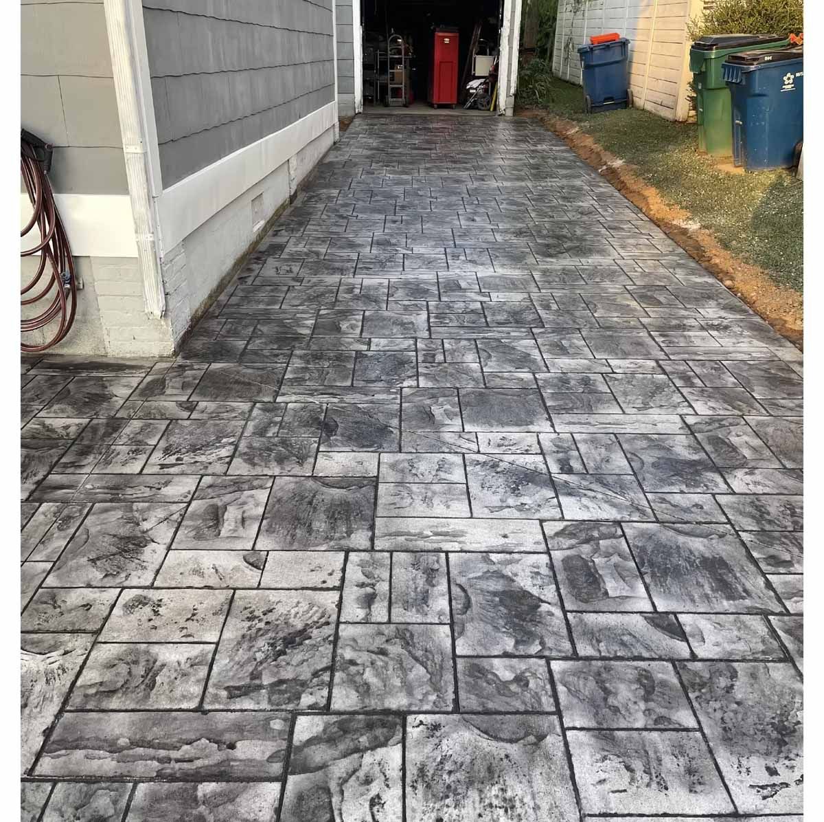 Stamped gray concrete driveway leading to a garage.
