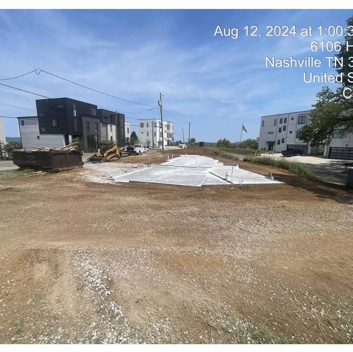 Construction site in Nashville, TN on Aug 12, 2024. Dirt and concrete foundation with buildings in the background.