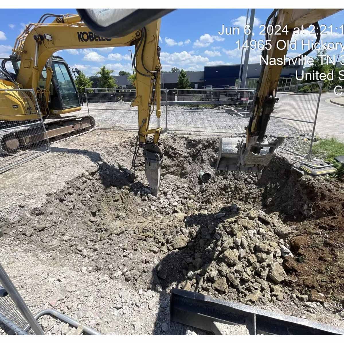 Two yellow excavators dig in a construction site in Nashville, TN.