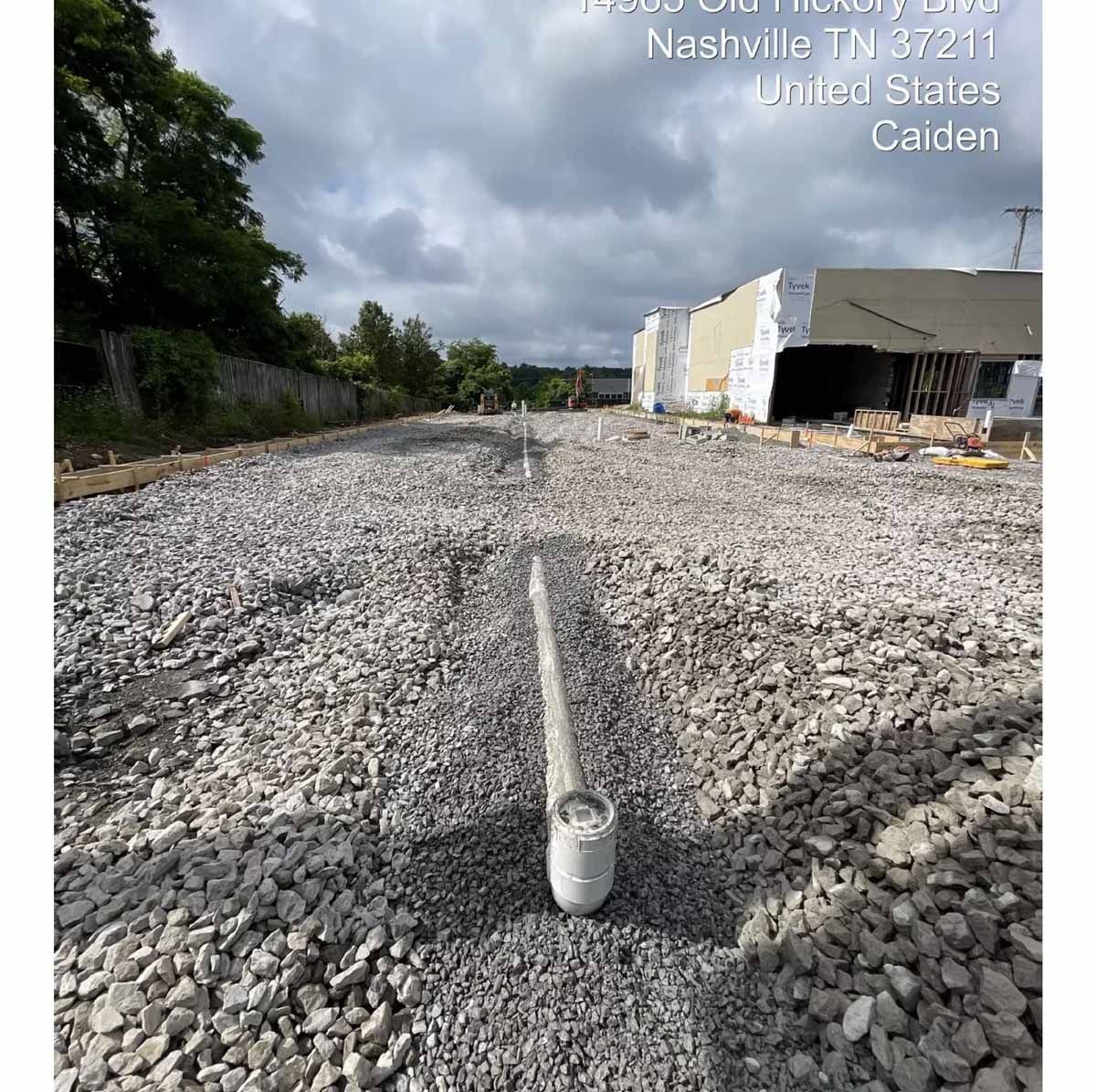 Gravel-covered construction site, 1350 McGavock Pike, Nashville. Cloudy sky. Marker in foreground.