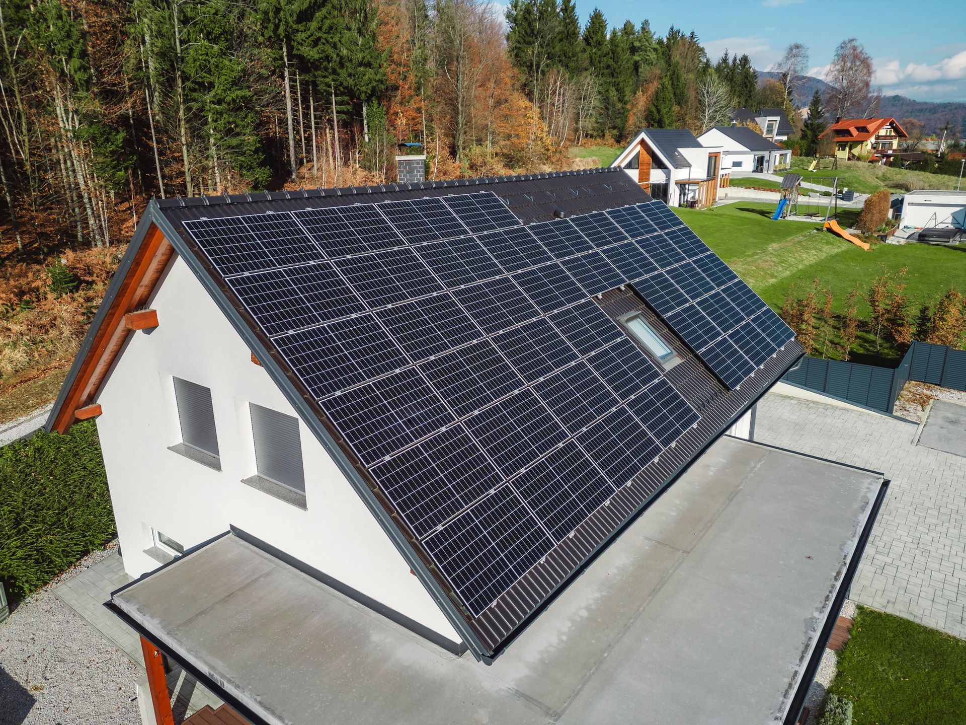 An aerial view of a house with solar panels on the roof.