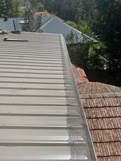 A close up of a metal roof with a tape measure on it.