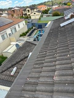 A roof with a lot of tiles on it and a pool in the background.