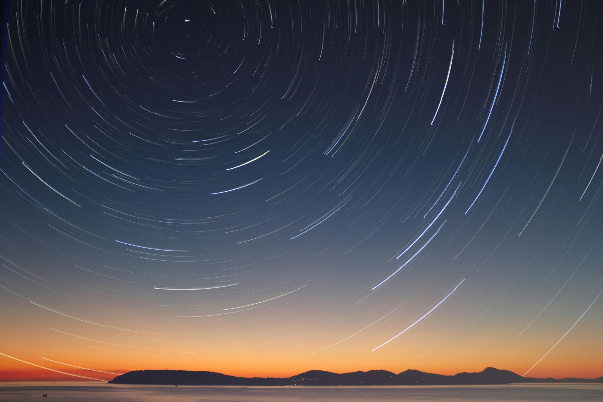 A star trail in the night sky over a body of water