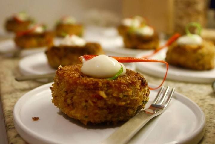 A wooden pergola with flowers and a table underneath it.