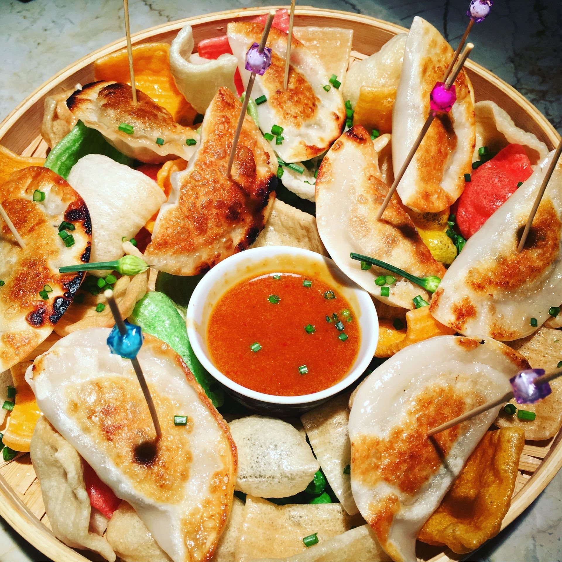 Arrangement of assorted fried seafood snacks, with a dipping sauce in the center.