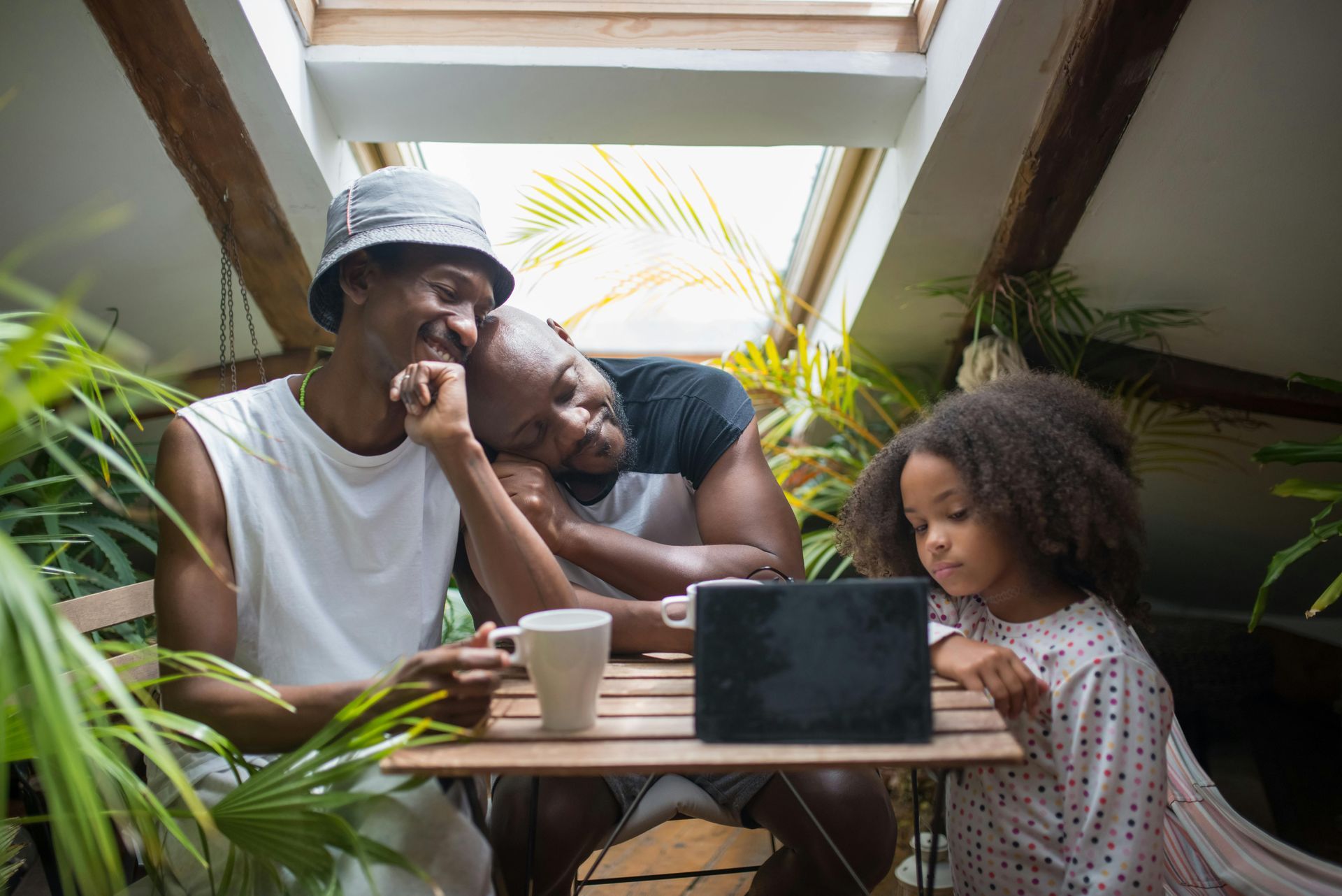 Family looking at a laptop in a kitchen, smiling.
