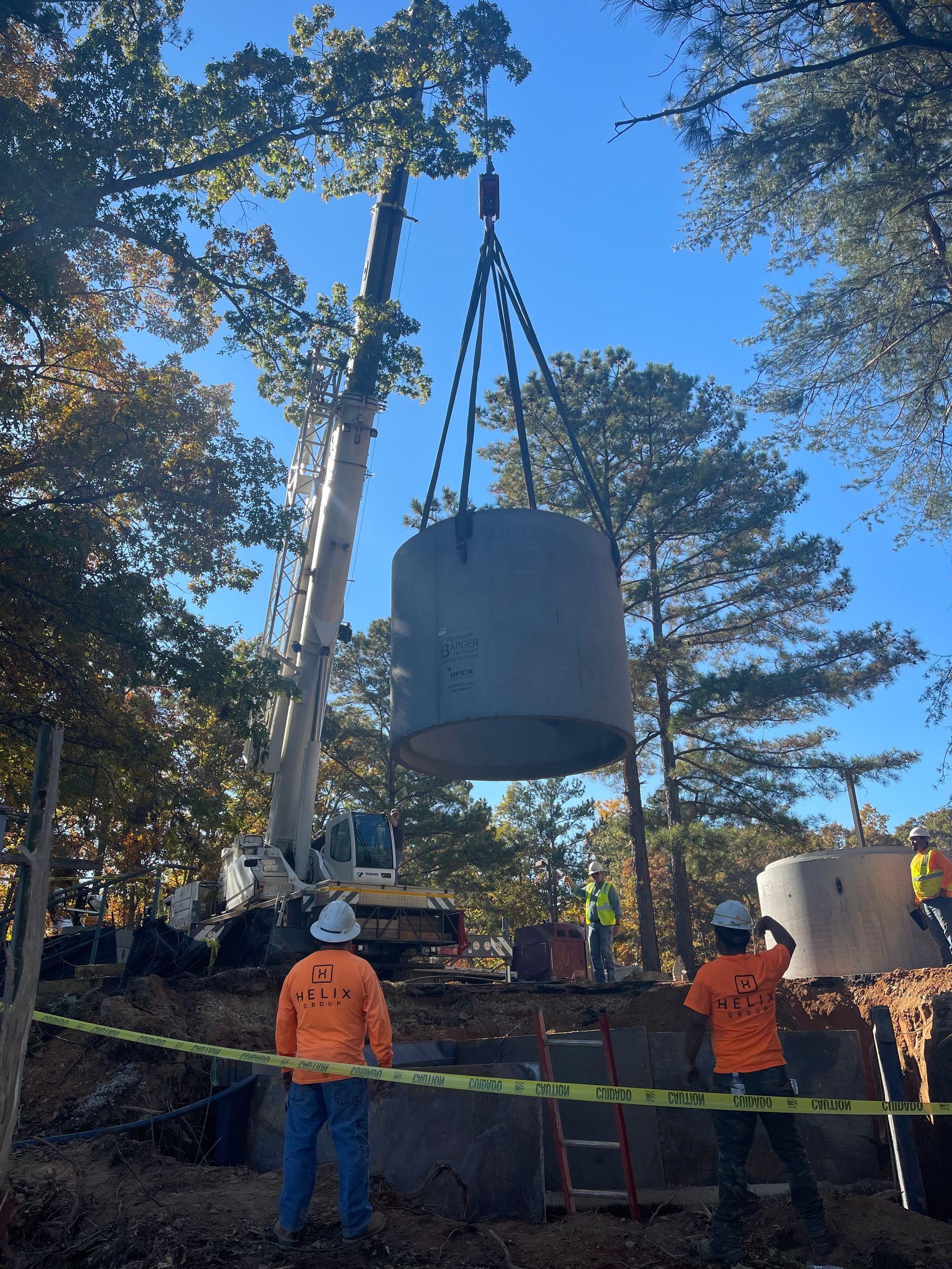 a large concrete cylinder is being lifted by a crane
