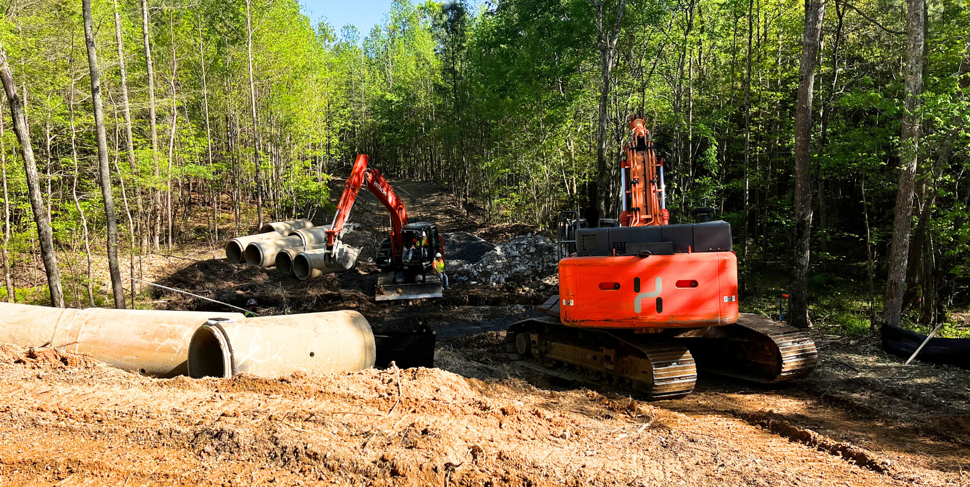 a man is standing next to a bulldozer on a dirt road .