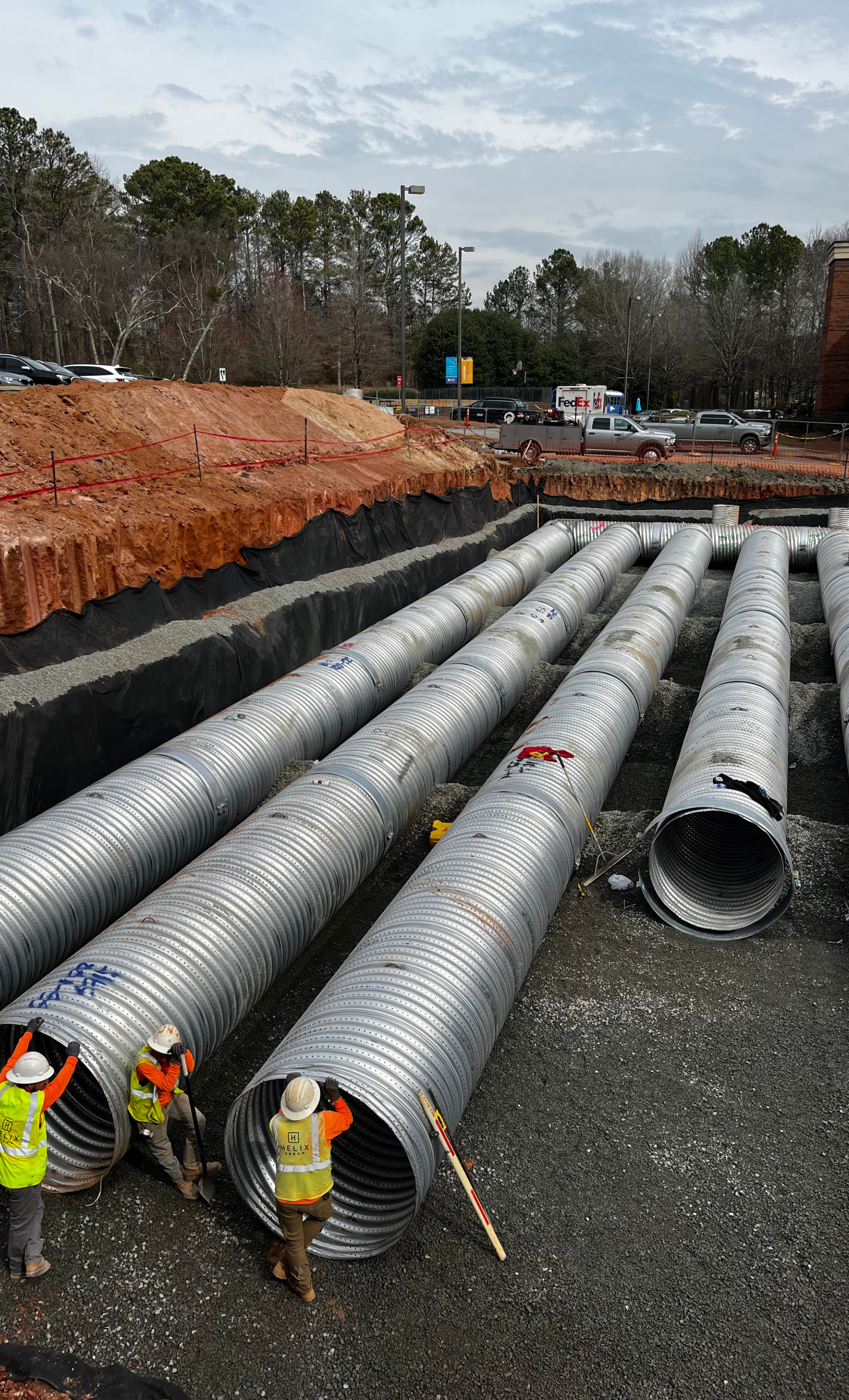 a group of construction workers are working on a pile of pipes .