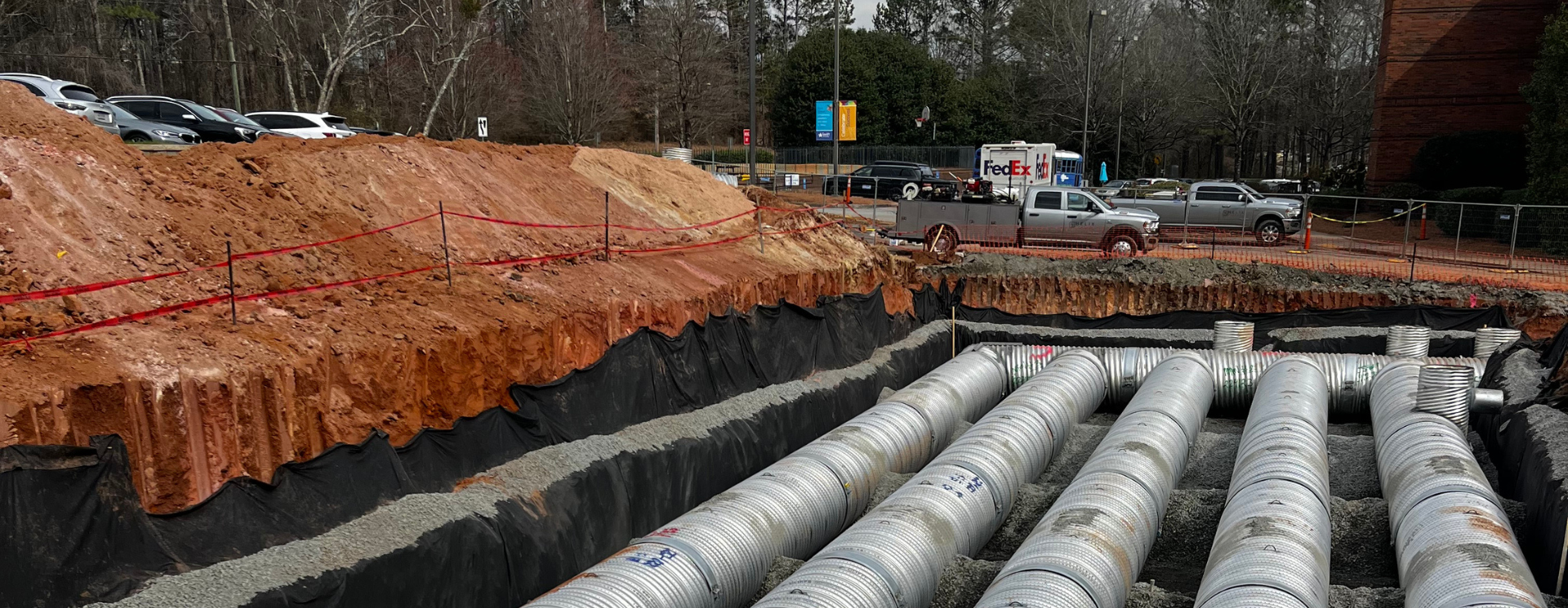 a bunch of pipes are laying in the dirt on a construction site .