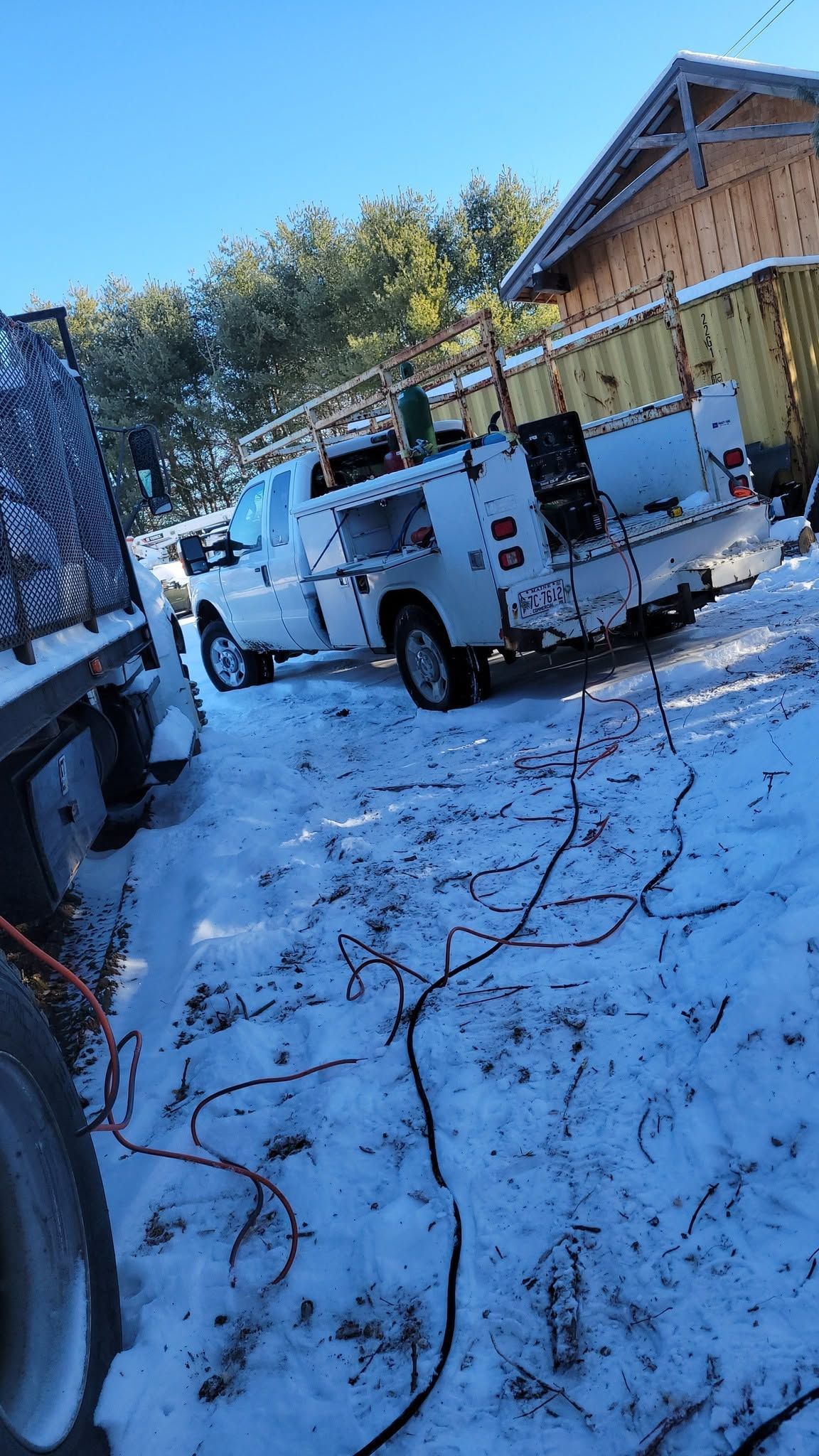 A white truck is parked in the snow in front of a building.