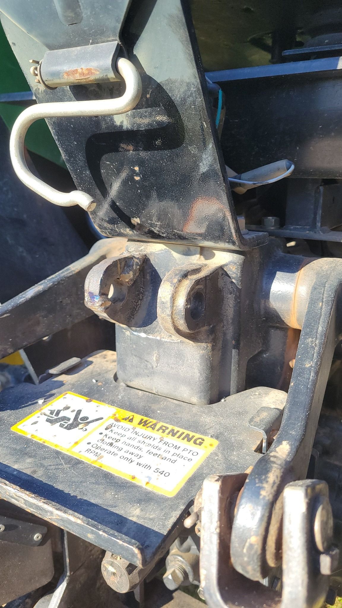 A close up of a tractor with a warning label on it.