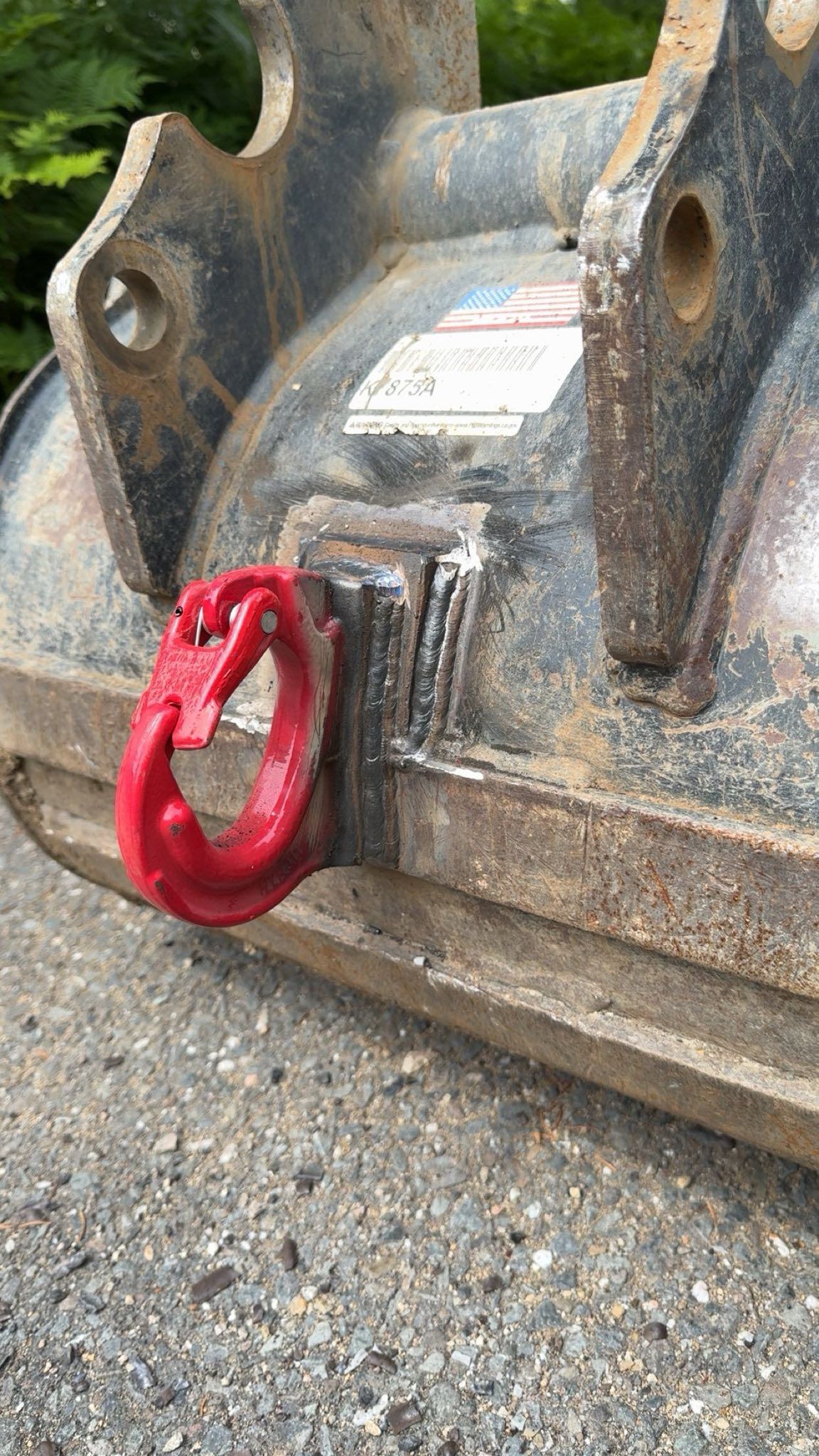 A red hook is attached to the back of a bulldozer bucket.