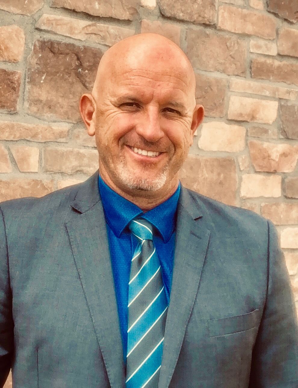 A camera operator wearing headphones stands behind a professional video camera recording a live stage event.