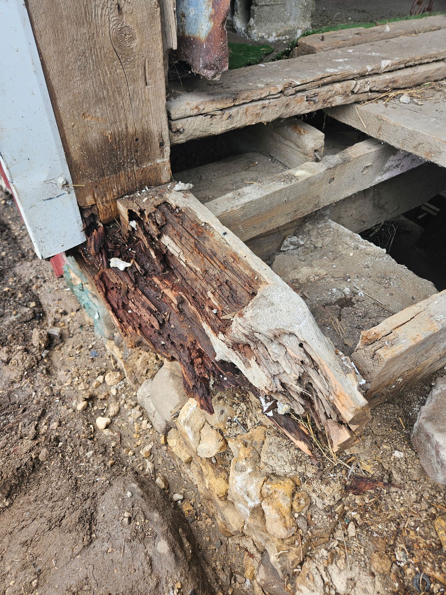 A piece of wood is sitting on top of a pile of dirt.