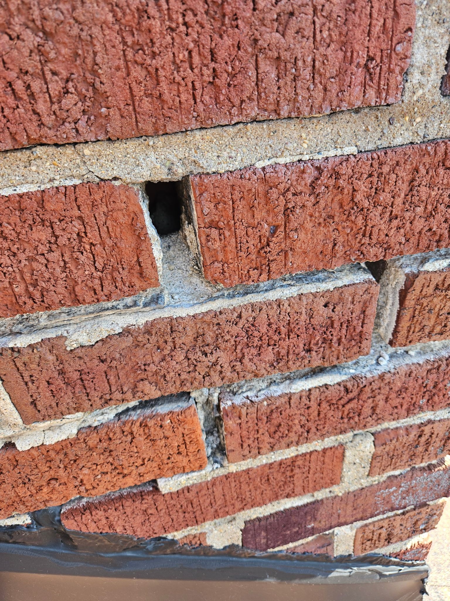 A close up of a brick wall with a hole in it.