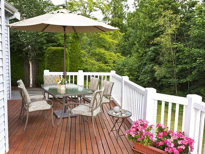 A deck with a table and chairs and an umbrella