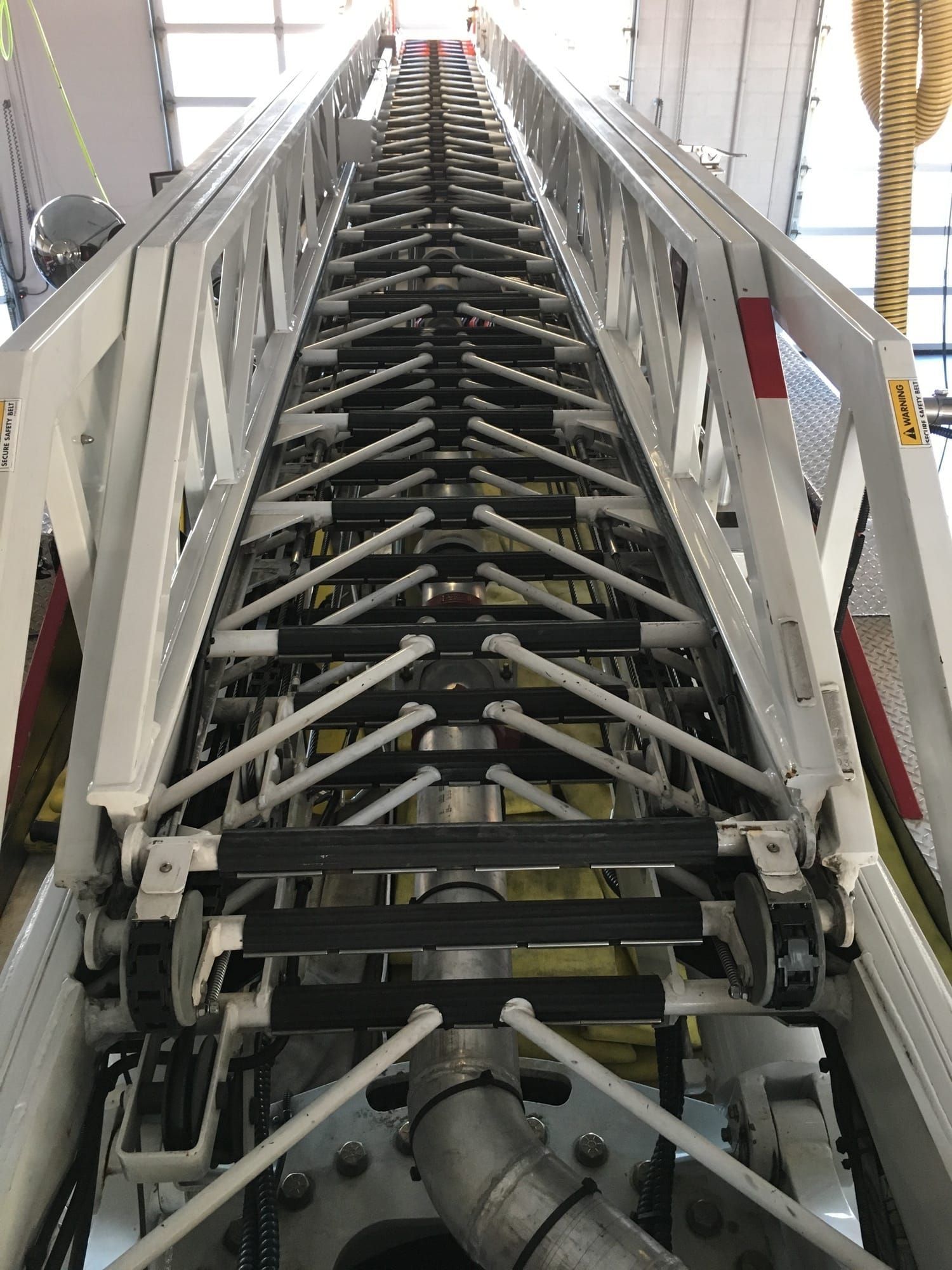 A close up of a ladder going up a building.