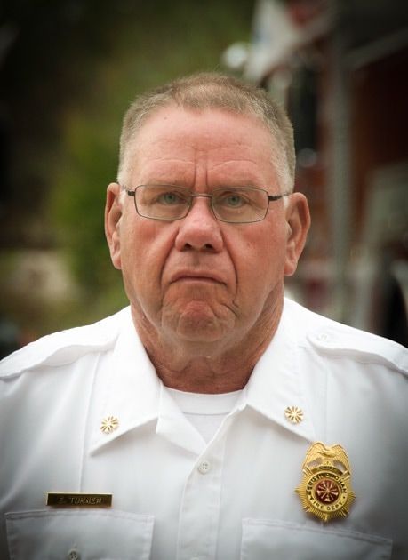 A man in a white uniform with a badge on his chest