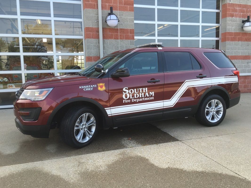 A red suv with the word south on the side is parked in front of a building.